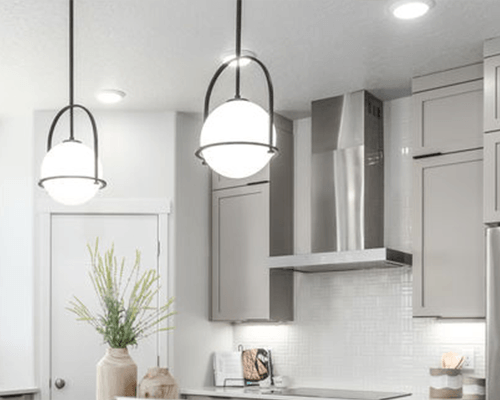 Photo of the inside of a Garbett Homes's home with two lamps holding and a plant inside a jar